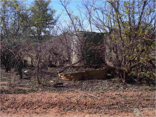 Stumps and corrugated iron tanks, Mungana