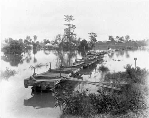 Flat wagons set up as a temporary bridge between Milton and Toowong, c1900