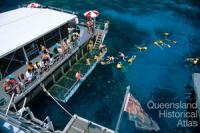 Tourists diving from a pontoon on the Outer Barrier Reef, 1991 