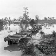 Flat wagons set up as a temporary bridge between Milton and Toowong, c1900