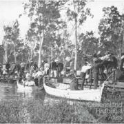 Railway passengers crossing Fitzroy River on flat wagons, c1900