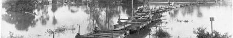 Flat wagons set up as a temporary bridge between Milton and Toowong, c1900